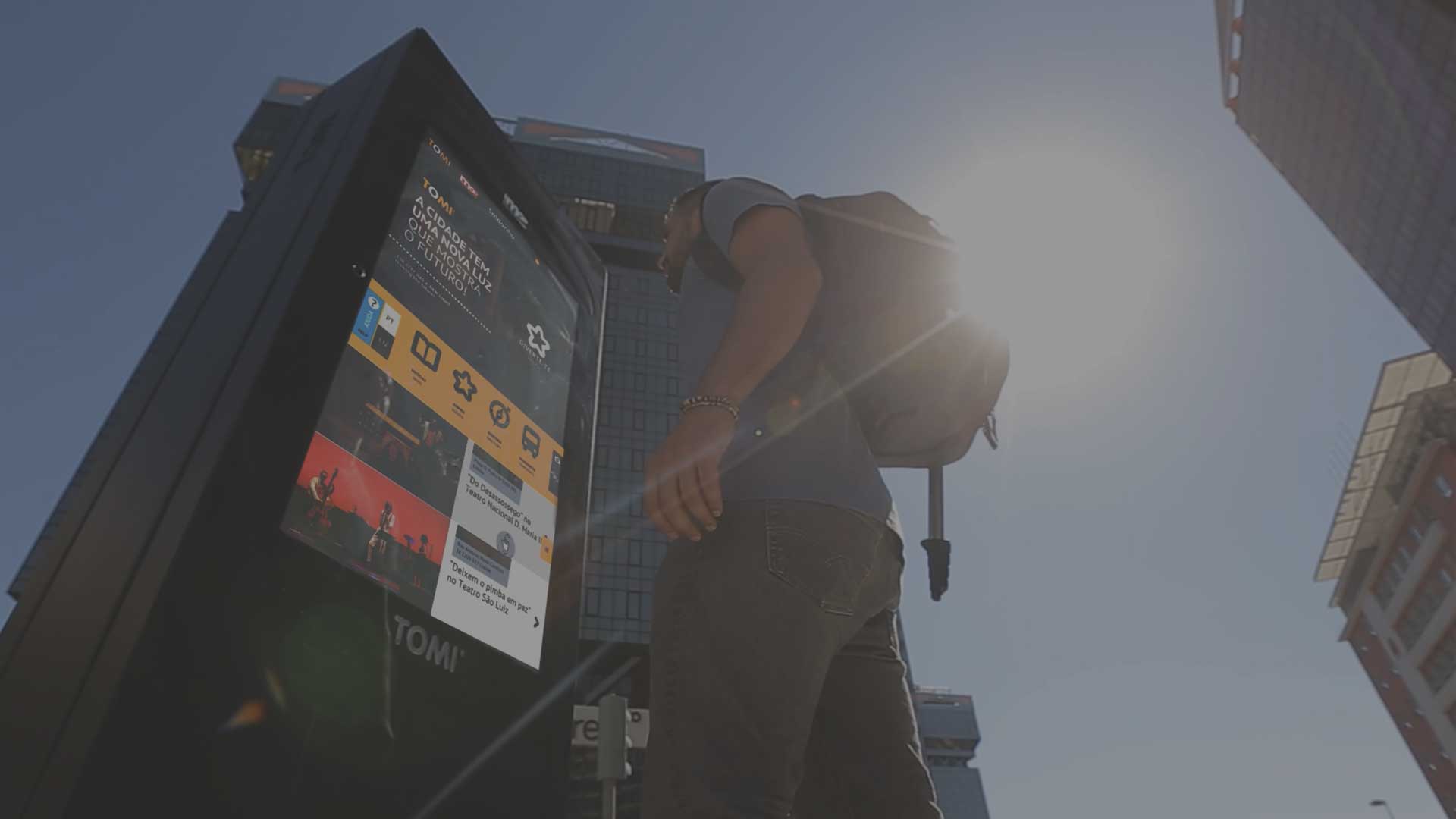 A man with TOMI digital kiosk in urban setting